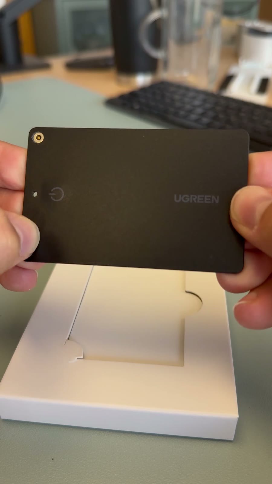 The UGREEN tracker card held over its box
